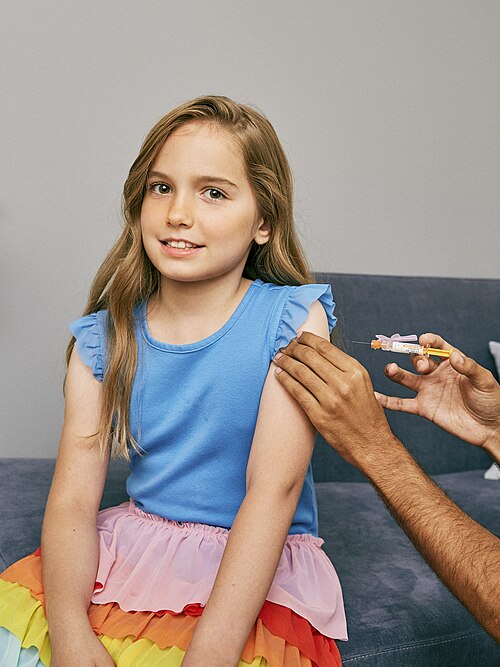 Child receiving a vaccine in the upper arm