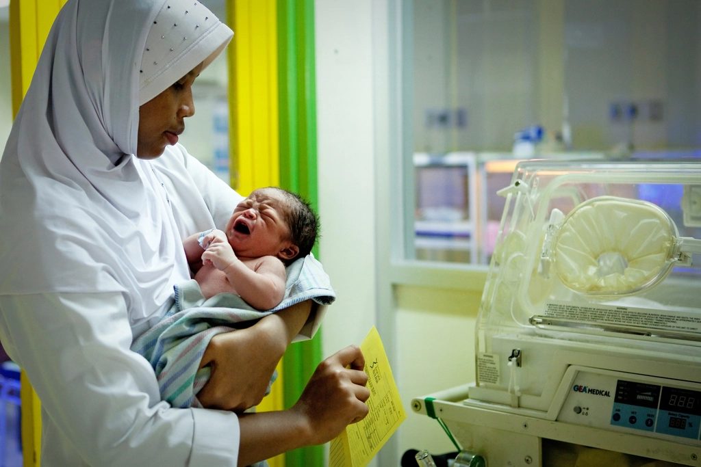 A nurse holding a newborn baby